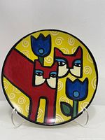 Front of plate showing red cats and blue tulips on yellow swirl background