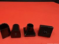 four loose black plastic tips of different shapes