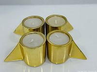 Top view of four brass tealight holders with candles