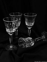 Set of four cut crystal cordial glasses upright and one on its side