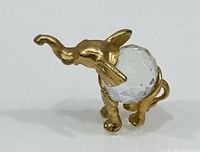 Front view of gold-tone metal elephant with clear faceted crystal body