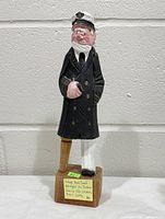 Full frontal view of carved sea captain figurine on base