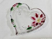 Top view of heart-shaped clear glass dish showing poinsettia and holly design