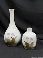 Front view of both porcelain vases showing thistle motif and overall forms