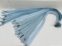 Bundle of light blue zippers fanned out