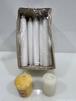 Box with six white taper candles and two votives