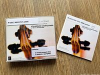 Front view of jewel case and separate booklet showing cover art and library stickers