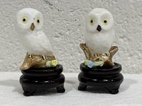 Front view of both porcelain owl figurines on stands