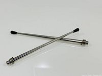 Two chrome antenna rods crossed showing overall appearance