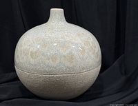 Full view of rounded crystalline glaze studio vase showing glossy upper section and matte lower section