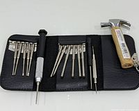 Open case showing micro screwdriver bits, driver handles and mini hammer