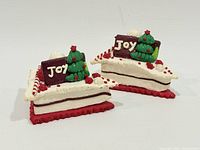 Two miniature Christmas cake decorations angled front view