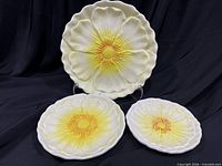Front view of all three ceramic flower plates displayed upright