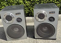 Front view of both Sony SP-E35 speakers showing drivers, grilles and overall condition