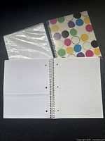Sealed loose-leaf paper pack, polka-dot notebook, open notebook pages