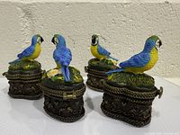 Four parrot trinket boxes displayed