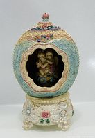 Front view showing egg music box with window exposing cherubs