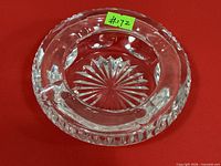 Top view of round clear cut crystal ashtray showing starburst base and faceted rim