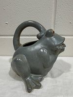 Left-side view of ceramic frog watering can showing overall shape and glaze