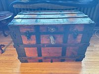 Front view of wooden trunk with metal banding and lock