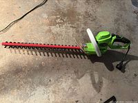 Full view of Greenworks corded hedge trimmer with 22-inch blade and power cord