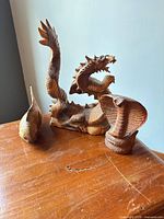 cobra, dragon and fish wooden figurines on tabletop