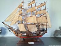 Full view of HMS Bounty model ship on stand showing sails, rigging, hull