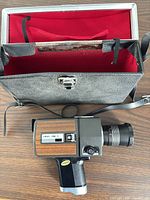 Camera with open carrying case showing red interior