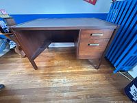 Full view of desk front, showing legs, drawers, overall structure