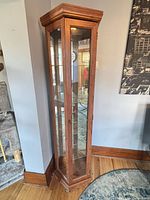 Full view of oak finish glass curio cabinet closed