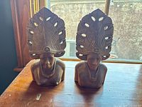 Front view of both carved wood bust bookends showing overall design and condition
