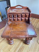 Front view showing table, upper section with 10 small drawers, turned legs