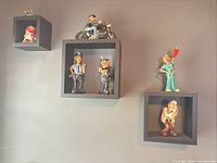 Wall display of six caricature figurines on cube shelves