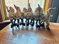 Front view of seven gnomes figurine on table