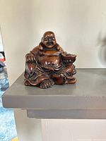 Front view of carved wood Laughing Buddha figurine