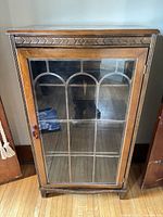 Front view of cabinet showing glass door and overall design