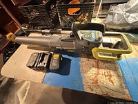 Leaf blower with battery inserted and charger nearby