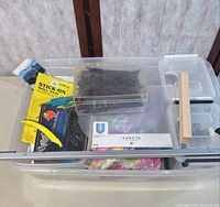 Plastic bin with assorted packaged items visible