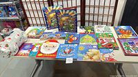Full lot showing all children’s holiday books laid on table with folded fleece throw blanket