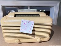 Front view of ivory Bakelite Crosley 56TU radio showing grille, knobs, and tuning window