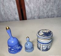 Large Currier & Ives bell, small Delft bell, covered Delft jar