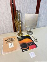 Trumpet, stand, two books, lyre on table