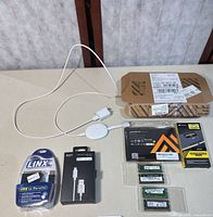 All items laid out: DIMM box, SO-DIMMs, cables, charger