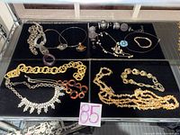 All 13 jewelry pieces arranged on black board