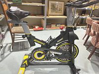 Left side profile of Pooboo D525DM bike showing frame, flywheel, saddle and stabilizers