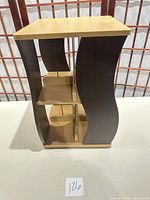 Front view of two-tone CD rack showing curved dark sides and light shelves