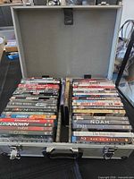 Open aluminum case displaying two rows of DVD/Blu-ray movies