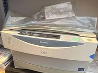 Front view of Canon PC940 copier with plastic cover and manual on top