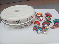 Roaster with lid and five glass sombrero ornaments on table