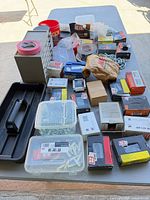 Table view showing boxes of screws, nails, anchors, tape rolls, chain, storage boxes and tool tray